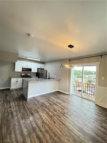a kitchen with stainless steel appliances granite countertop a stove and a wooden floors