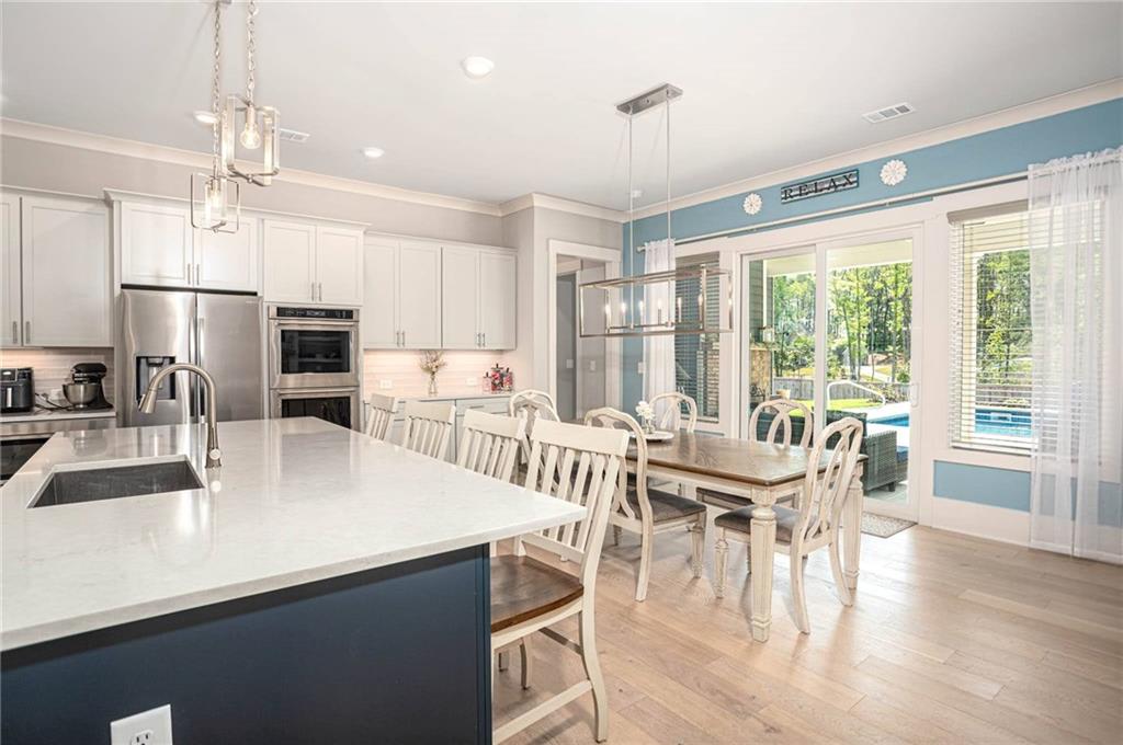 255 Old Town Road Dacula, GA 30019 - Photo 15 of 38 a kitchen with stainless steel appliances a dining table chairs a refrigerator and cabinets
