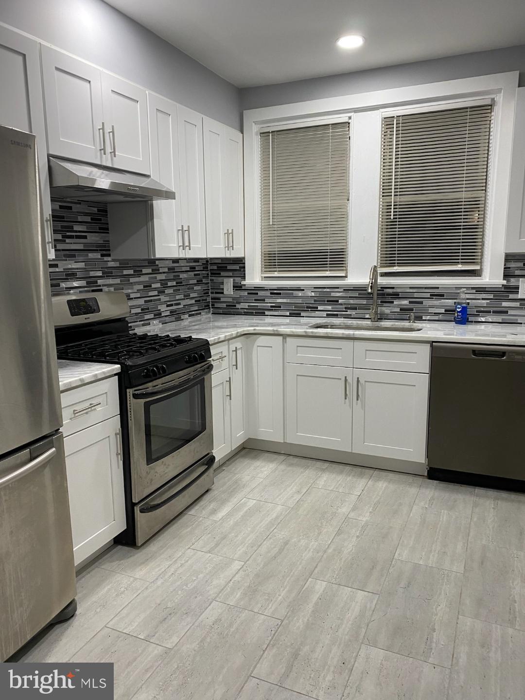 5324 Horrocks Street Philadelphia, PA 19124 - Photo 1 of 25 a kitchen with granite countertop a stove sink and cabinets