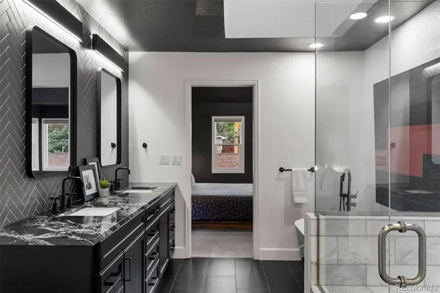 a en suite bathroom with a double vanity sink a large mirror and shower