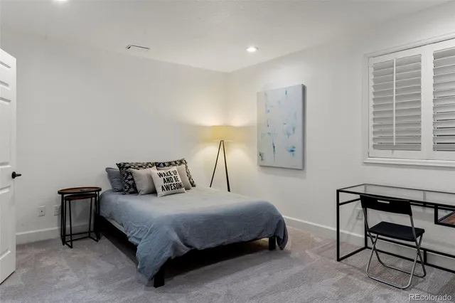 a bedroom with a bed a desk and chair