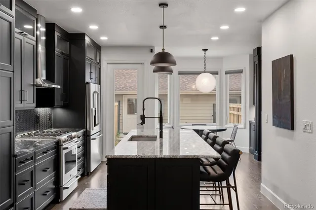 a kitchen with stainless steel appliances a sink stove and refrigerator
