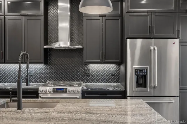 a kitchen with stainless steel appliances granite countertop a refrigerator and a stove