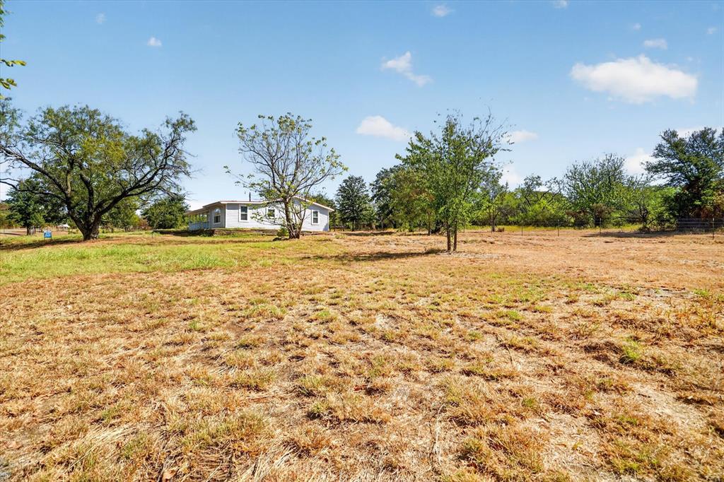 795 Meadow Road Springtown, TX 76082 - Photo 21 of 25 Expansive lot with mature trees and a single-story residence