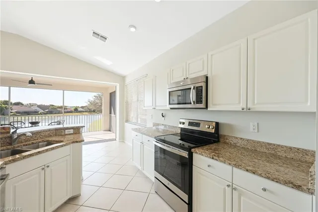 a kitchen with stainless steel appliances granite countertop a stove a sink and a microwave
