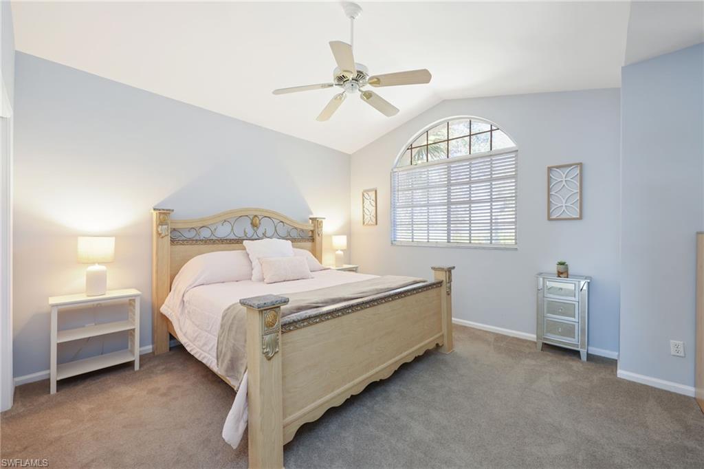 7828 Gardner Drive, Unit 5202 Naples, FL 34109 - Photo 22 of 44 a spacious bedroom with a bed and a chandelier