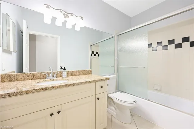 a bathroom with a granite countertop sink a toilet and shower