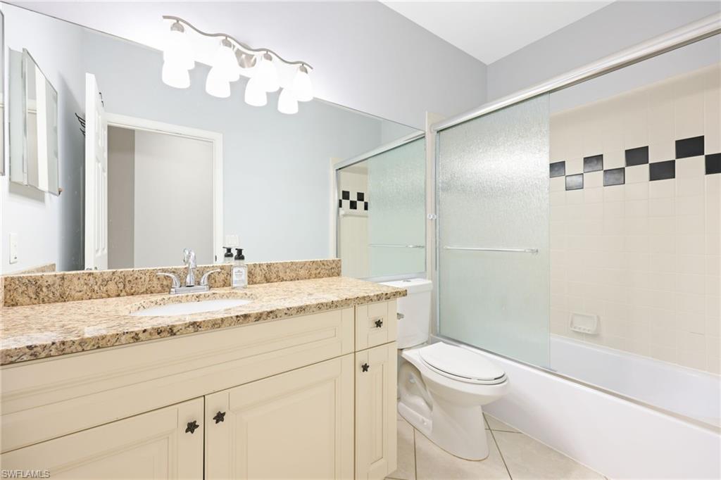 7828 Gardner Drive, Unit 5202 Naples, FL 34109 - Photo 25 of 44 a bathroom with a granite countertop sink a toilet and shower