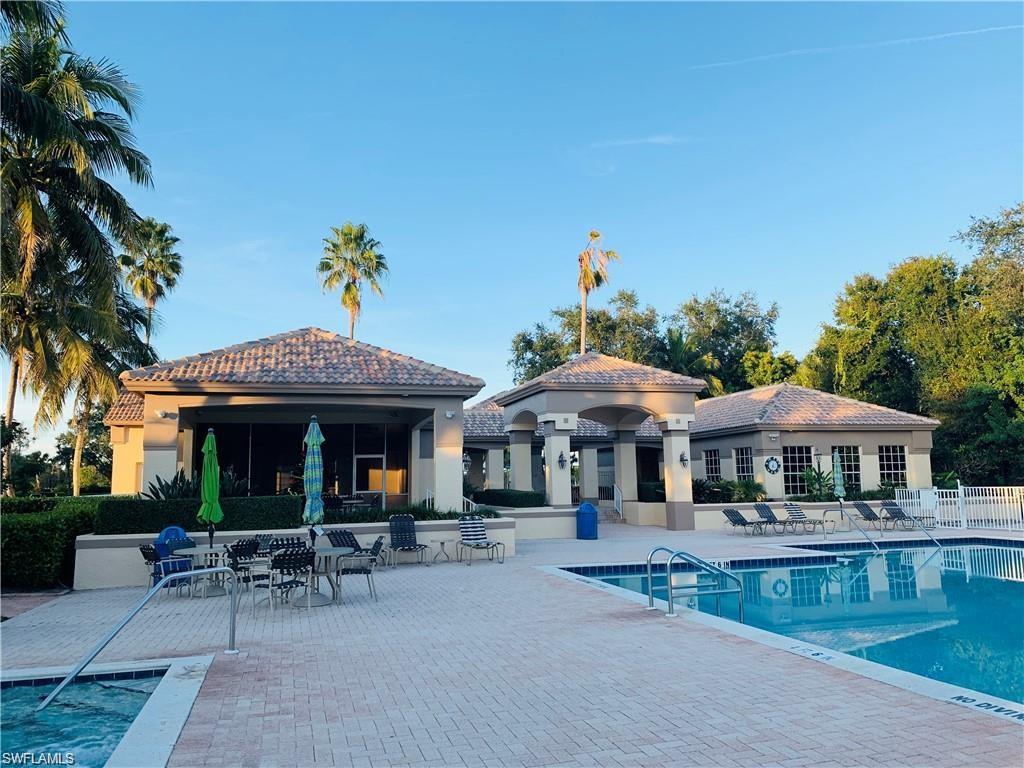7828 Gardner Drive, Unit 5202 Naples, FL 34109 - Photo 35 of 44 a view of a table and chairs under an umbrella