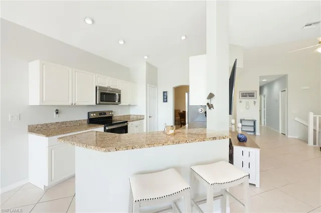 a kitchen with stainless steel appliances granite countertop a sink refrigerator and cabinets