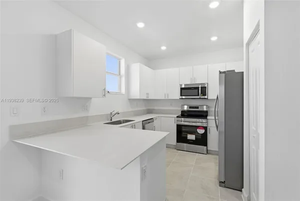 a kitchen with stainless steel appliances a refrigerator stove microwave and sink