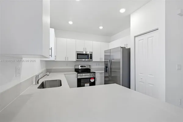 a kitchen with a sink stove and microwave