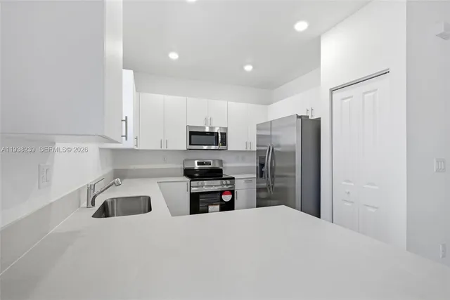 a kitchen with a sink stove and microwave
