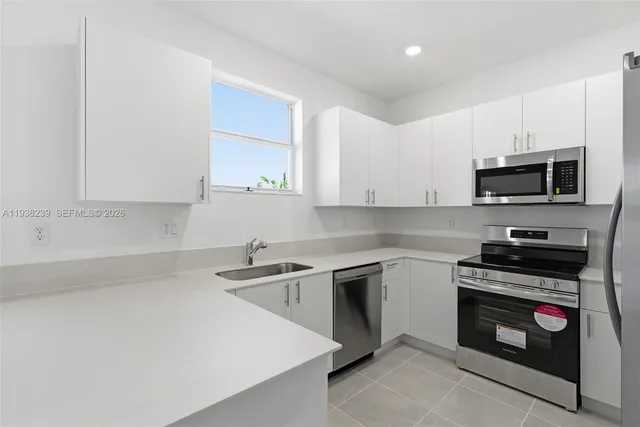 a kitchen with stainless steel appliances a refrigerator sink and microwave