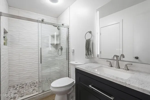 a bathroom with a granite countertop sink toilet and shower