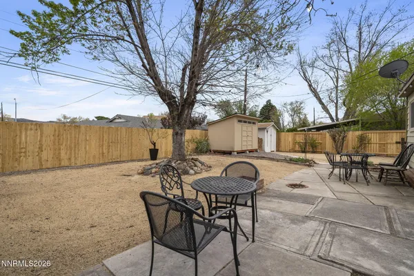 a view of a patio with table and chairs with wooden fence and plants
