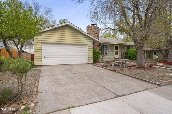 a front view of house with yard and trees around
