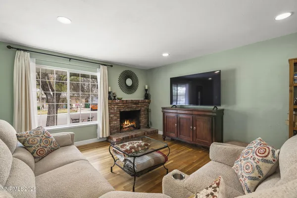 a living room with furniture a flat screen tv and a fireplace