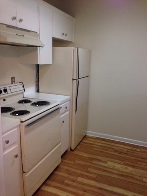 5001 Bull Creek Road, Unit 117 Austin, TX 78731 - Photo 6 of 10 Kitchen featuring white electric range, light countertops, and white cabinetry