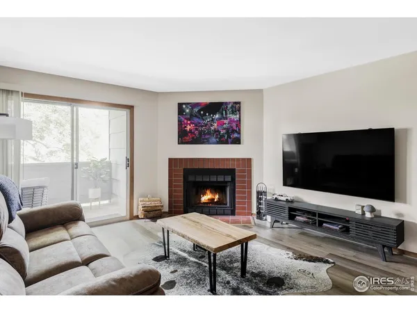 a living room with furniture a flat screen tv and a fireplace