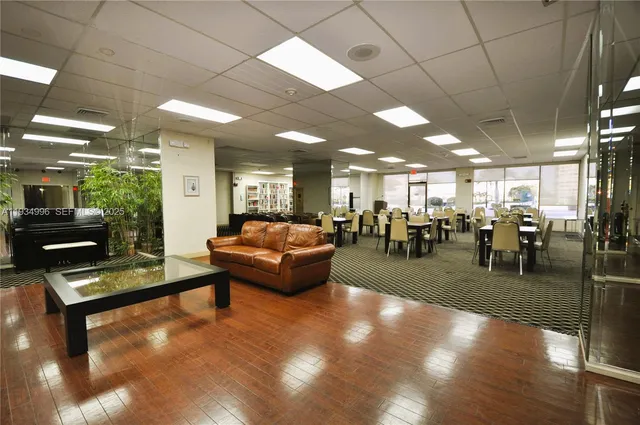 a living room with lots of furniture and a view of kitchen
