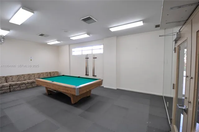 a room with pool table and windows
