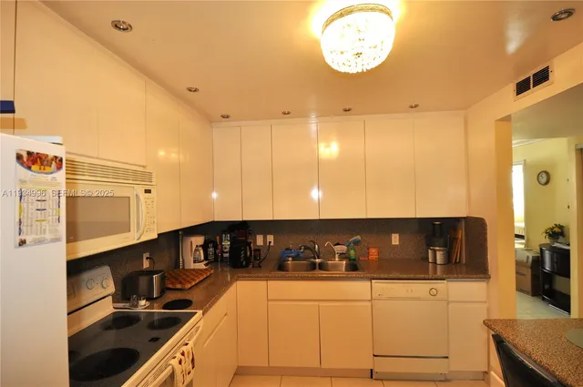 a kitchen with stainless steel appliances granite countertop a sink and cabinets