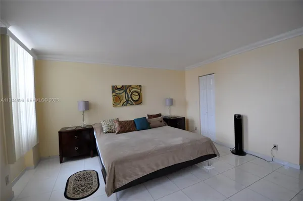 a bedroom with a bed and a lamp on dresser