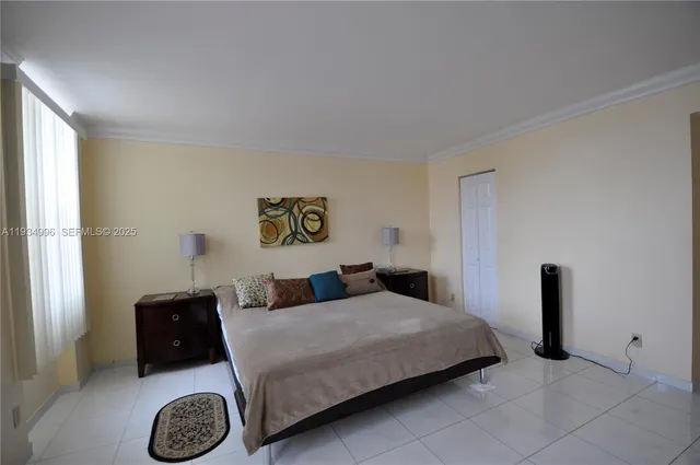 a bedroom with a bed and a lamp on dresser