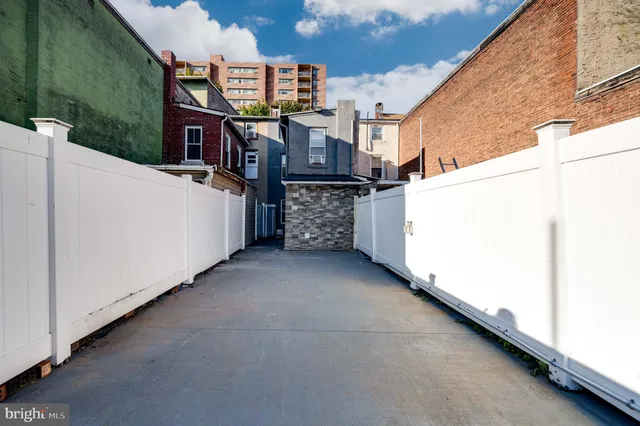 a view of a house with roof and wooden fence