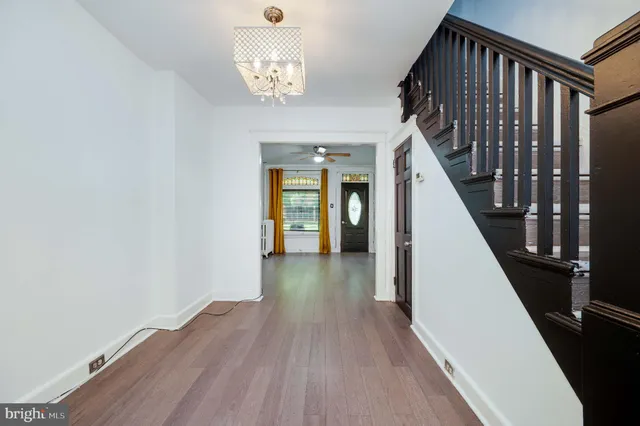 a view of a hallway with wooden floor and staircase