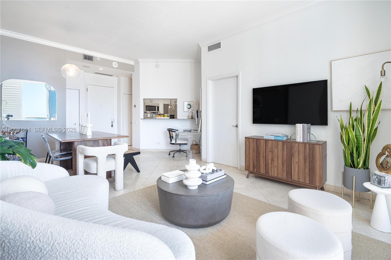 888 Brickell Key Drive, Unit 2602 Miami, FL 33131 - Photo 4 of 29 a living room with furniture a flat screen tv and a potted plant