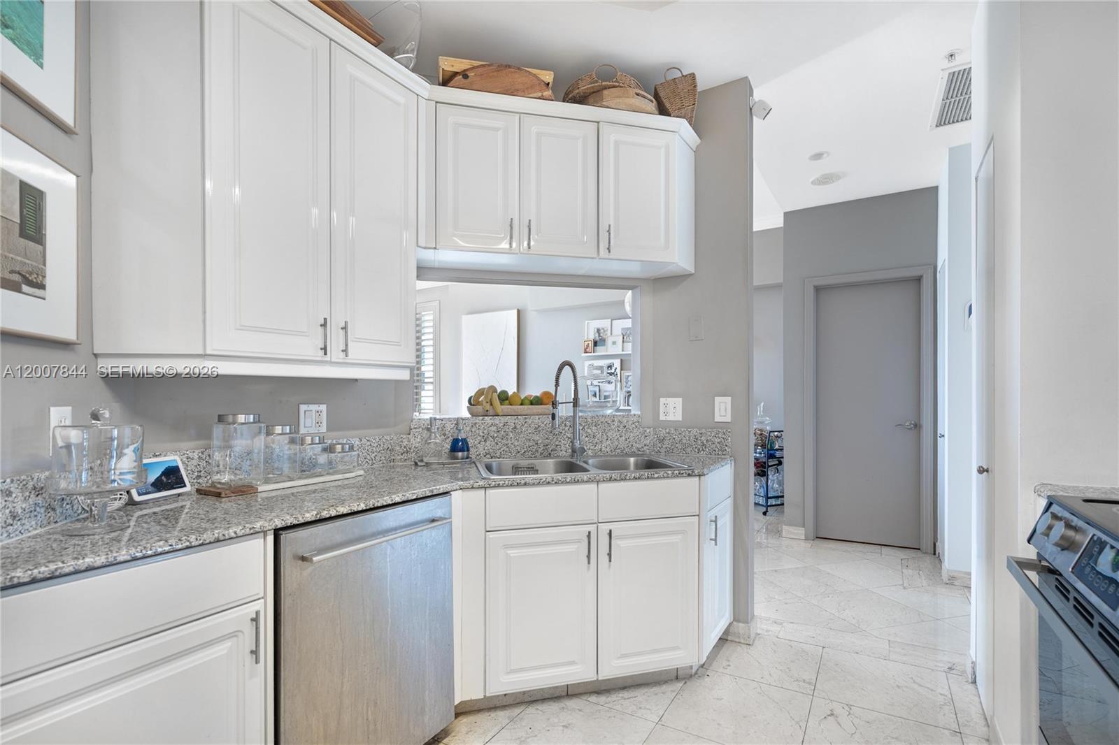 888 Brickell Key Drive, Unit 2602 Miami, FL 33131 - Photo 9 of 29 a kitchen with stainless steel appliances granite countertop a sink and dishwasher with white cabinets