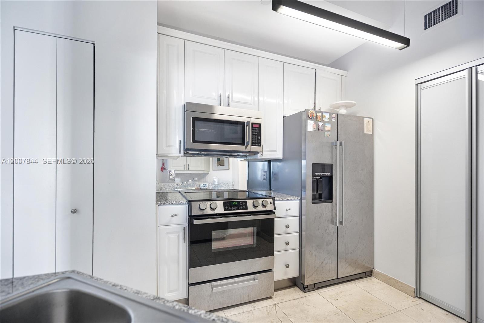 888 Brickell Key Drive, Unit 2602 Miami, FL 33131 - Photo 10 of 29 a kitchen with stainless steel appliances a refrigerator stove and microwave