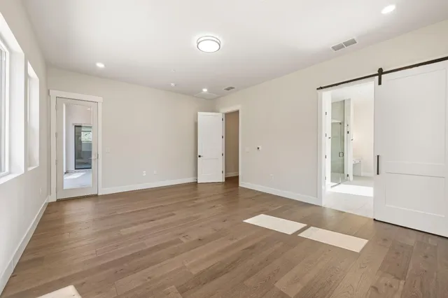 a spacious en suite bathroom with a granite countertop sink mirror and shower
