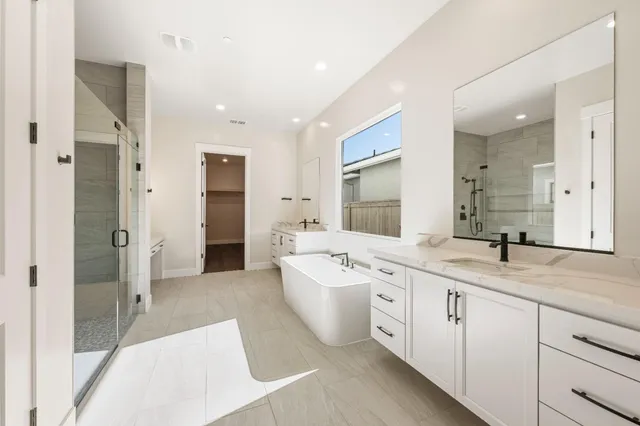 a large bathroom with a double vanity sink a large mirror and shower