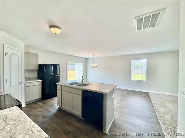 a kitchen with stainless steel appliances granite countertop a refrigerator and a stove top oven
