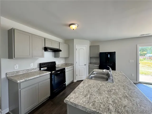 a kitchen that has a sink and a stove in it