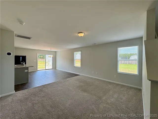 an empty room with windows fireplace and windows