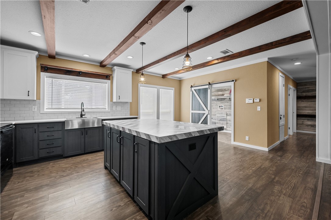 1511 Monkey Road Rockport, TX 78382 - Photo 12 of 40 a kitchen with a stove a sink a refrigerator and wooden cabinets