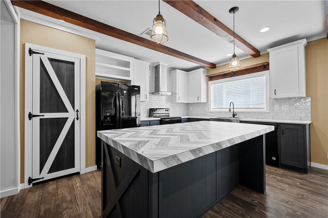 1511 Monkey Road Rockport, TX 78382 - Photo 14 of 40 a kitchen with a stove a refrigerator a sink and dishwasher with wooden floor