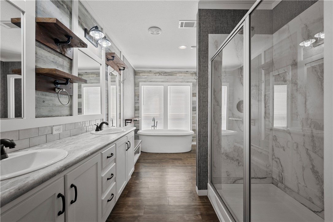 1511 Monkey Road Rockport, TX 78382 - Photo 23 of 40 a bathroom with a double vanity sink and mirror with shower