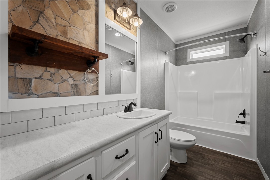 1511 Monkey Road Rockport, TX 78382 - Photo 29 of 40 a bathroom with a granite countertop sink a toilet a mirror and bathtub