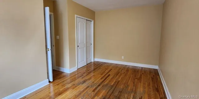 a view of a room with wooden floor and a window