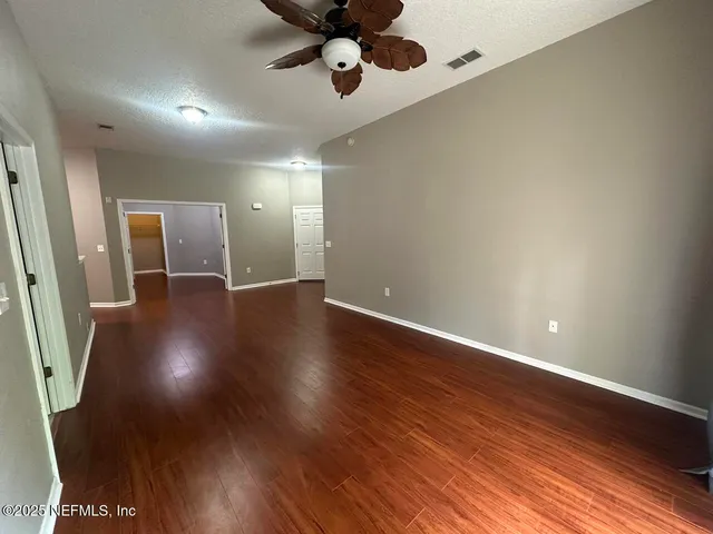 a view of an empty room with wooden floor