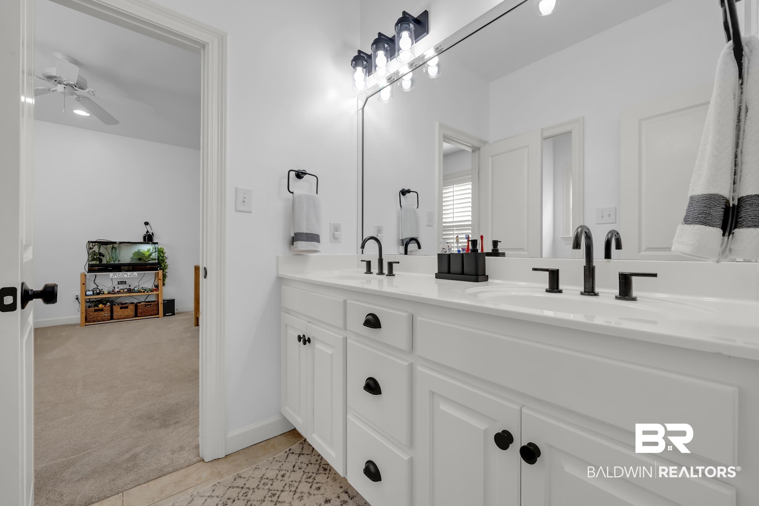 8137 Pine Run Daphne, AL 36527 - Photo 31 of 67 Double vanity with white cabinetry, matte black hardware, and an expansive mirror
