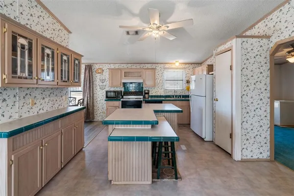 a kitchen with kitchen island granite countertop a sink appliances and cabinets