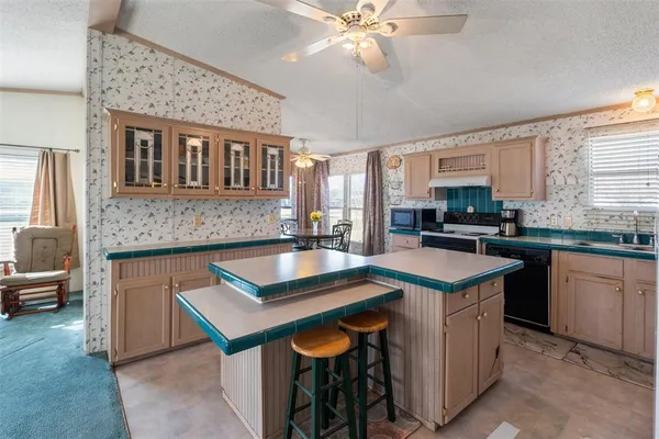 a kitchen with stainless steel appliances granite countertop a sink a stove counter space and dining table