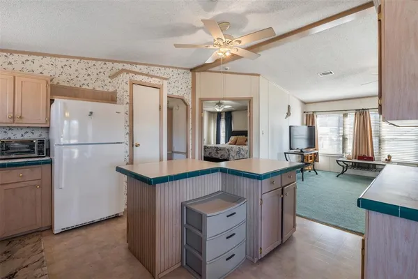a kitchen with kitchen island a sink a stove and a refrigerator