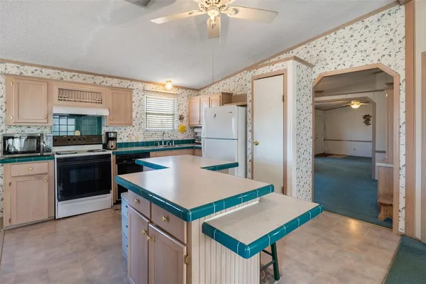 a kitchen with a stove a refrigerator a sink dishwasher with a dining table and chairs